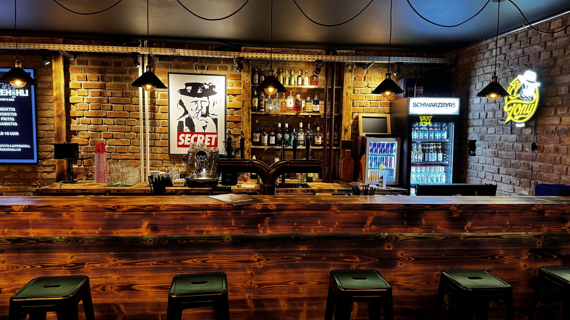 Die Bar im Bärehöhli mit Backsteinwand und Barhockern